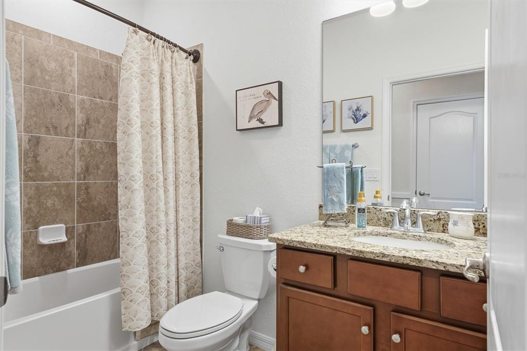 10475 Medjool Drive Venice, FL 34293 - Photo 40 of 71 a bathroom with a granite countertop toilet a sink and a bathtub