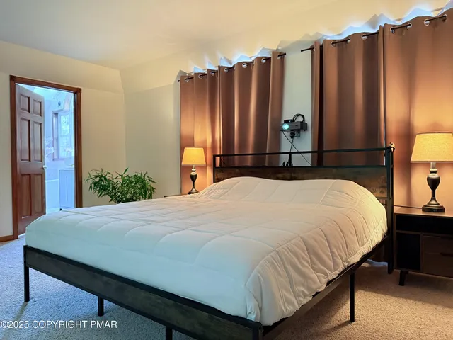 a bedroom with a bed a dresser and a large mirror