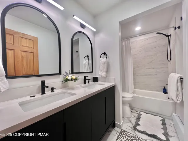 a bathroom with a double vanity sink toilet and shower