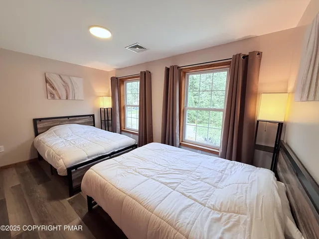 a bedroom with two beds and a large window