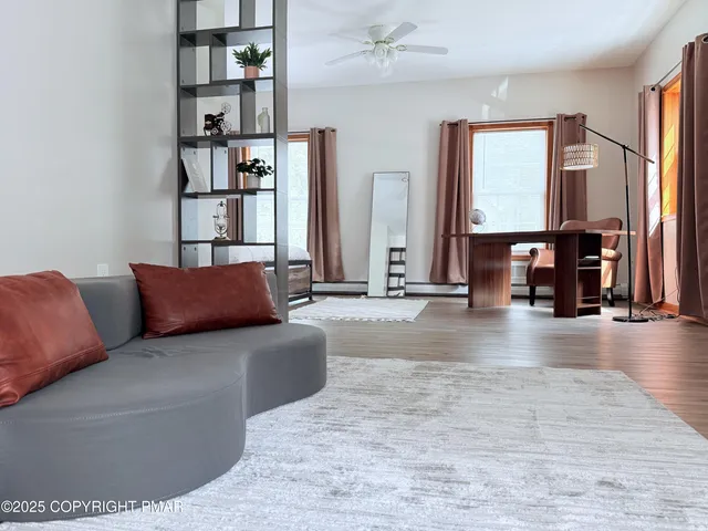 a living room with furniture a bookshelf and a window