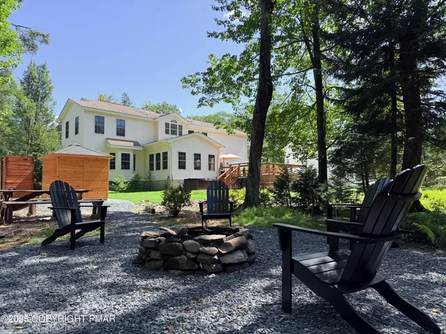 a view of a house with backyard and sitting area