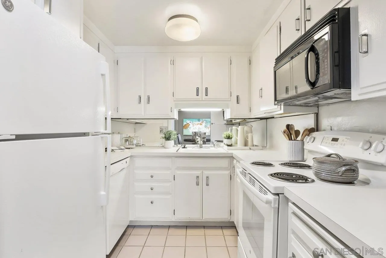 939 Coast Boulevard, Unit 4H La Jolla, CA 92037 - Photo 12 of 39 a kitchen with stainless steel appliances granite countertop a sink a stove and cabinets