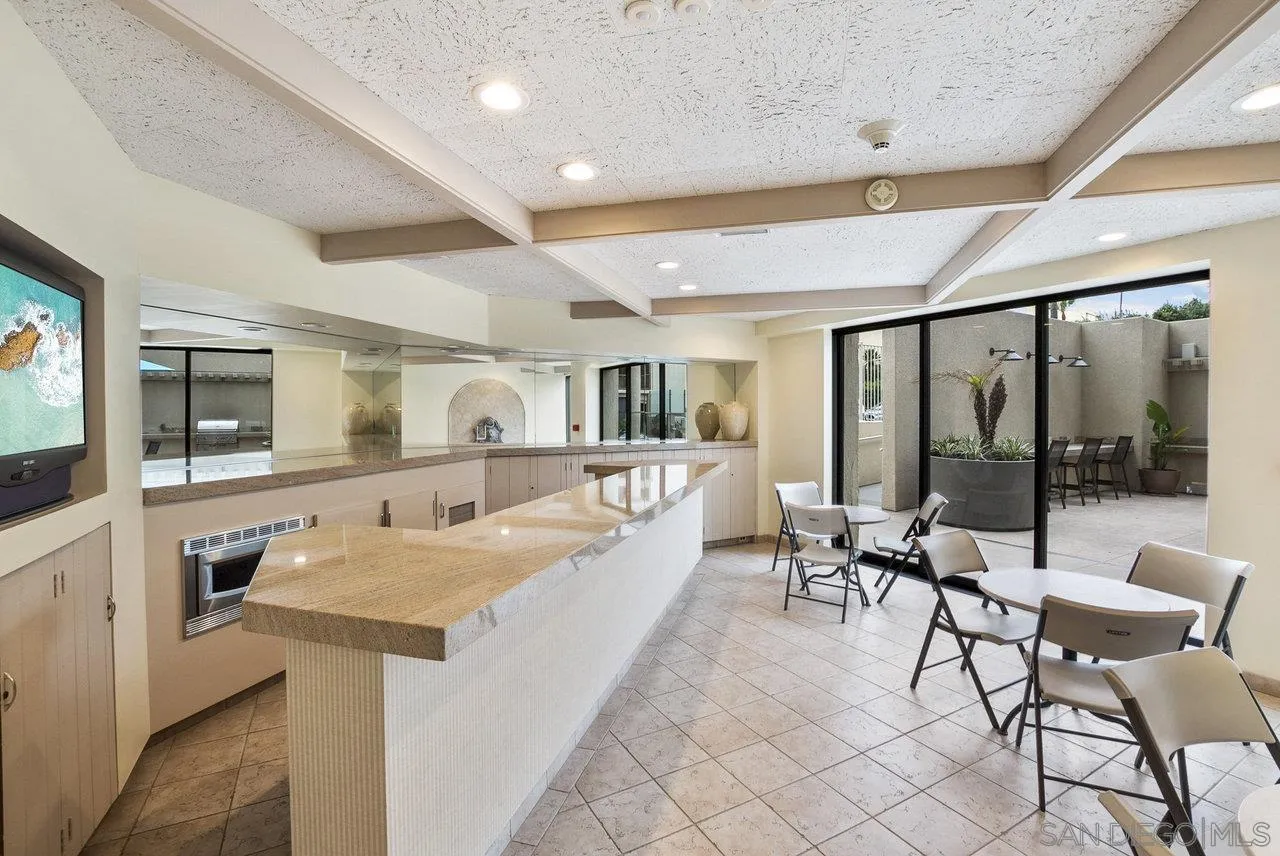 939 Coast Boulevard, Unit 4H La Jolla, CA 92037 - Photo 30 of 39 a living room with furniture a flat screen tv and a floor to ceiling window