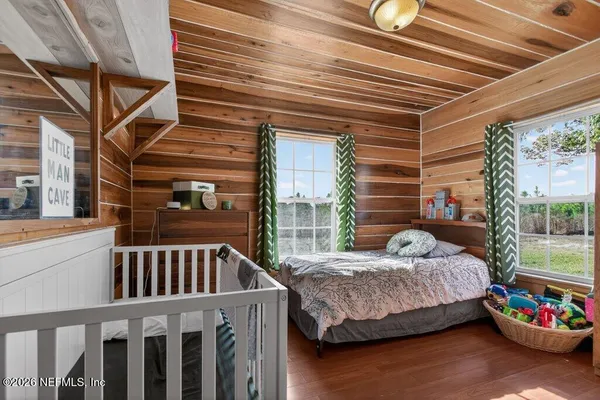 a bed sitting in a bedroom next to a window