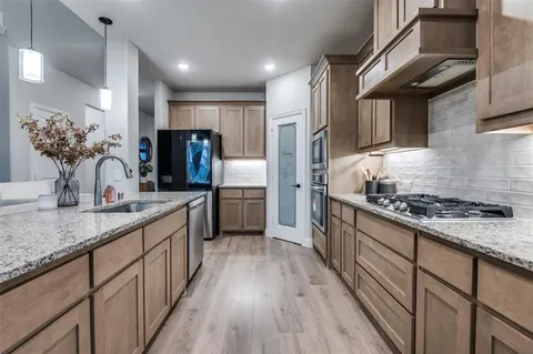 a kitchen with stainless steel appliances granite countertop a sink a stove oven and granite counter tops