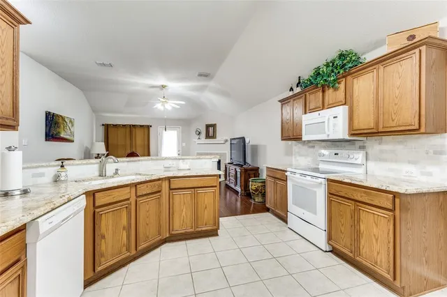 a large kitchen with stainless steel appliances granite countertop a sink and cabinets