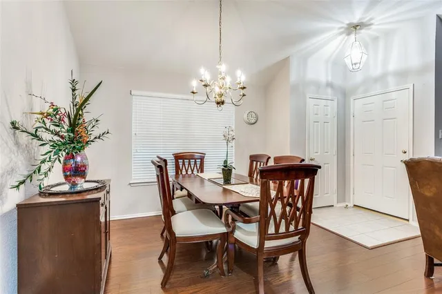 a dining room with furniture potted plants and wooden floor