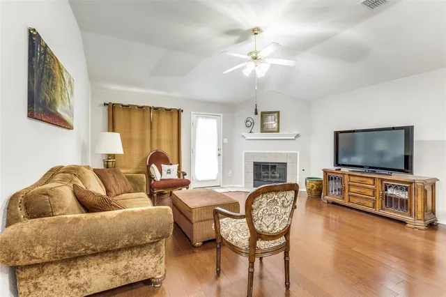 a living room with furniture a flat screen tv and wooden floor