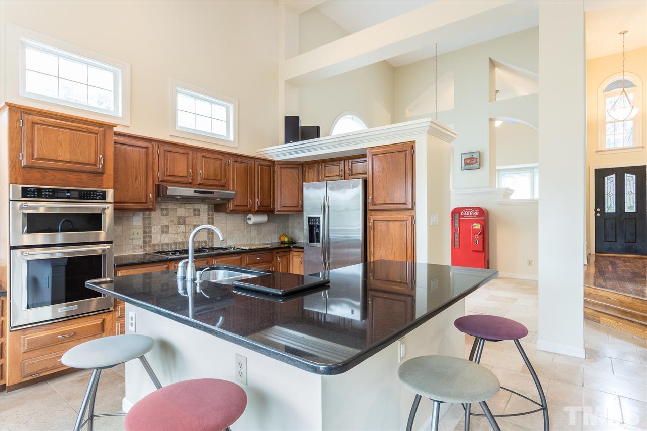 10121 Goodview Court Raleigh, NC 27613 - Photo 17 of 30 a kitchen with stainless steel appliances granite countertop a sink and a refrigerator