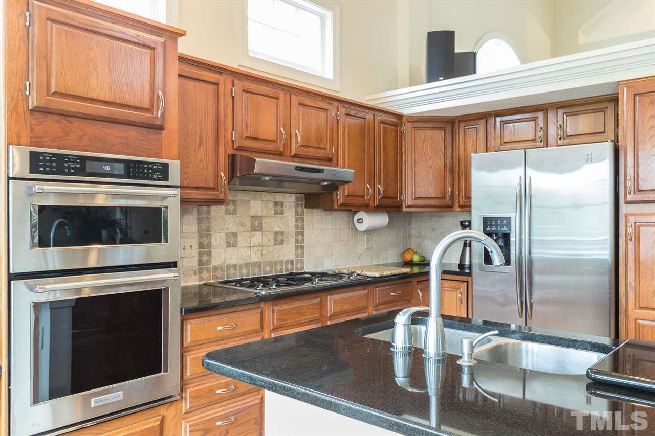 10121 Goodview Court Raleigh, NC 27613 - Photo 18 of 30 a kitchen with stainless steel appliances granite countertop a stove top oven a sink and dishwasher