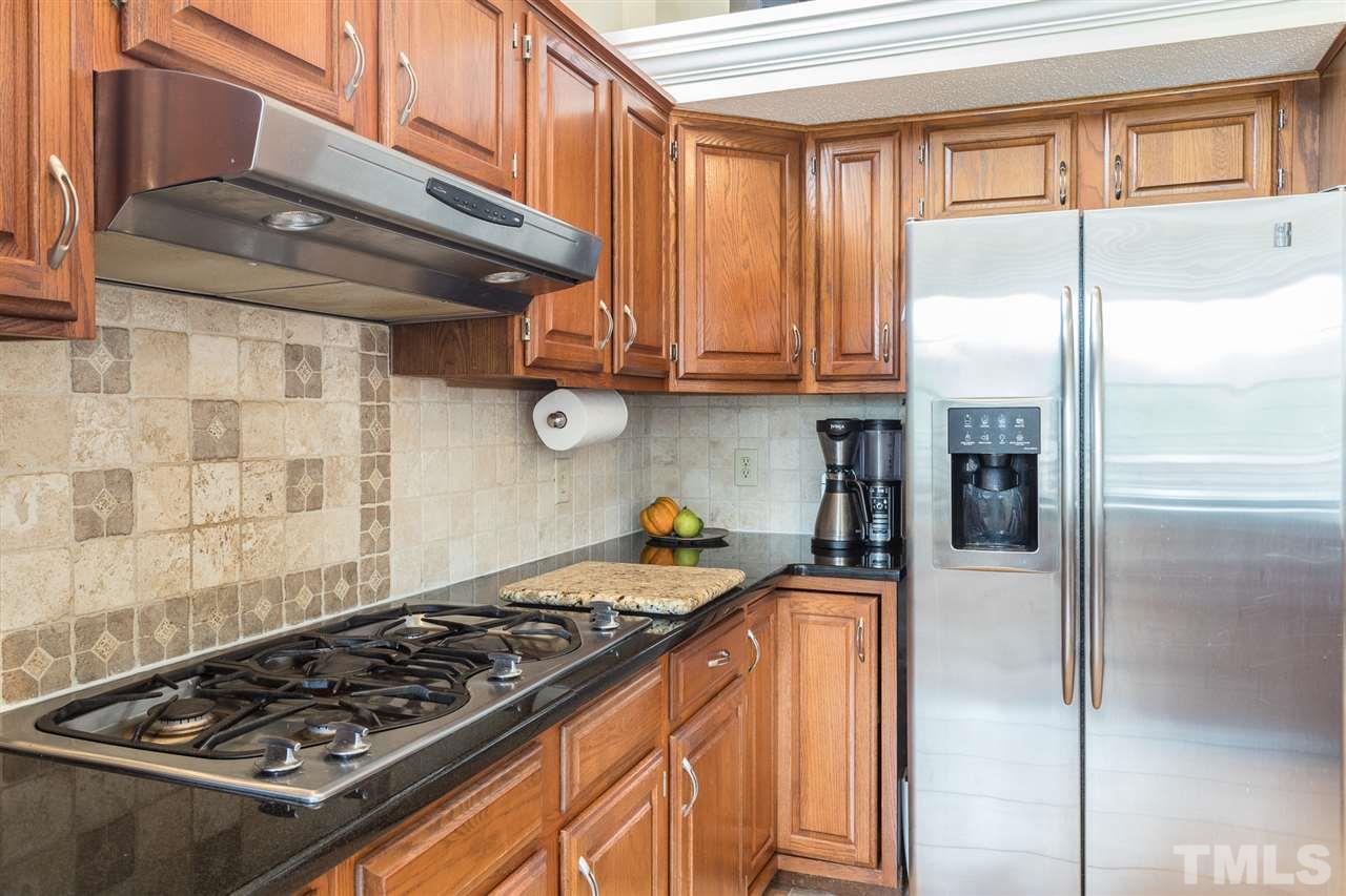 10121 Goodview Court Raleigh, NC 27613 - Photo 19 of 30 a kitchen with stainless steel appliances granite countertop a stove and a refrigerator