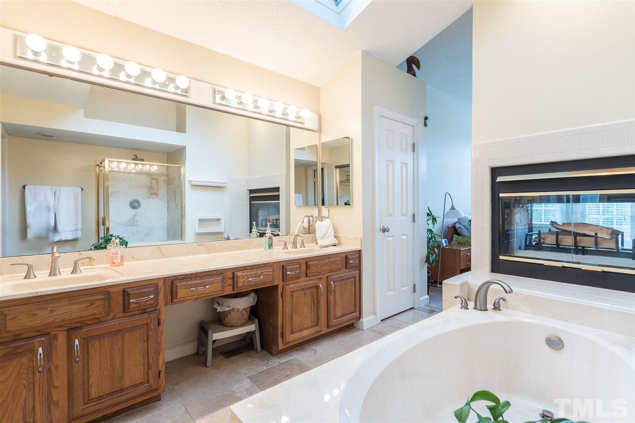 10121 Goodview Court Raleigh, NC 27613 - Photo 25 of 30 a bathroom with a tub a sink and mirror