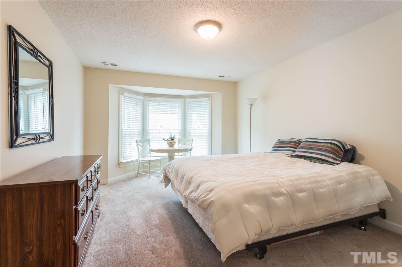 10121 Goodview Court Raleigh, NC 27613 - Photo 30 of 30 a bedroom with a bed and a large mirror