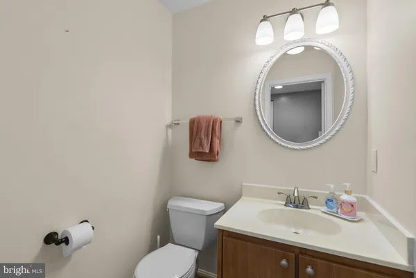 a bathroom with a toilet sink vanity and mirror
