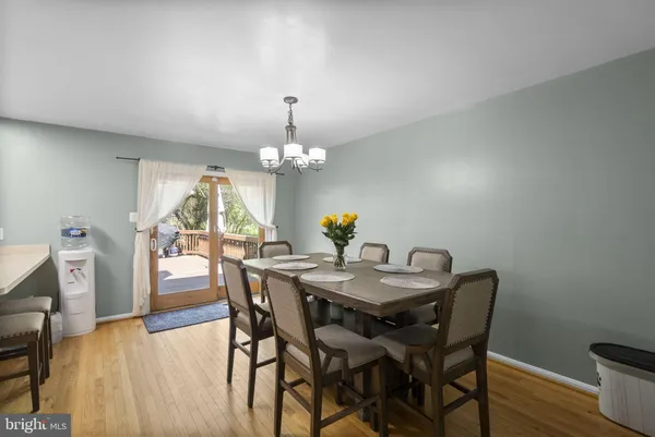 a view of a dining room with furniture a chandelier and wooden floor