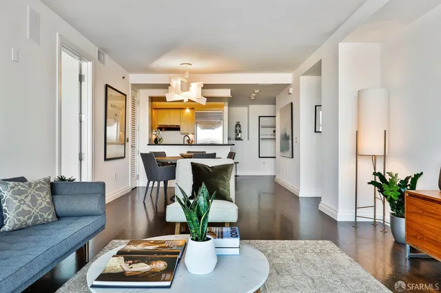 a kitchen with a stove a sink and a dining table with wooden cabinet