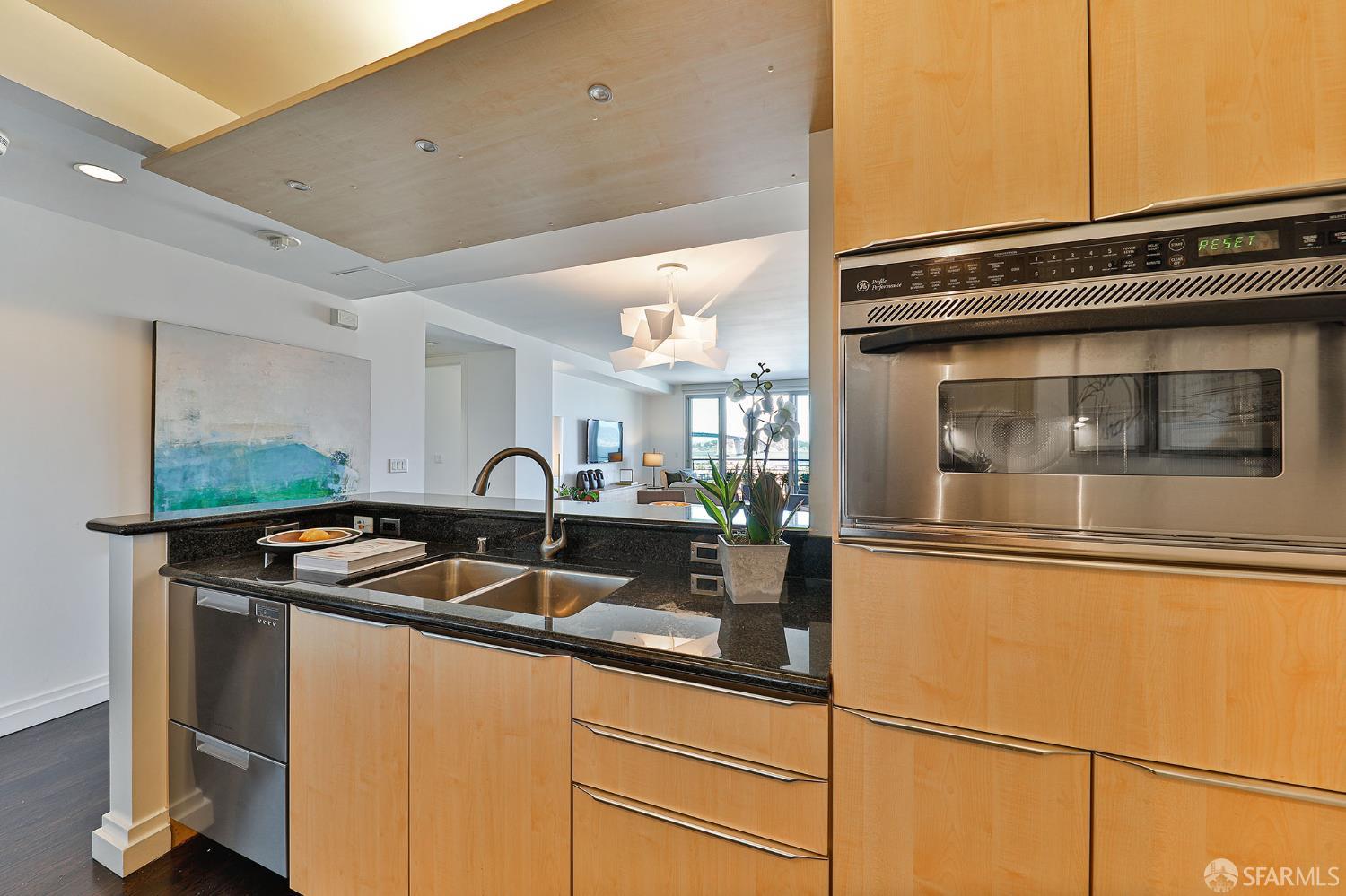229 Brannan Street, Unit 12C San Francisco, CA 94107 - Photo 19 of 57 a kitchen with stainless steel appliances granite countertop a sink and a microwave