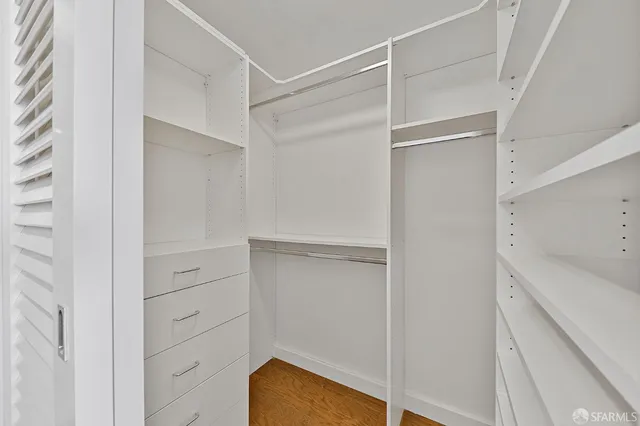 a view of walk in closet with empty racks