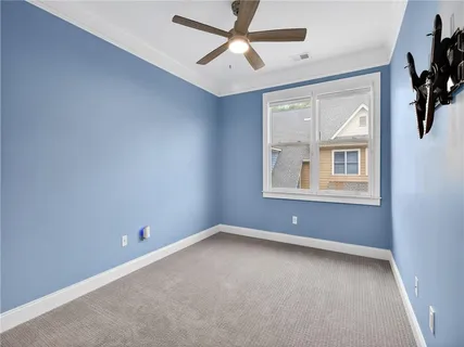 an empty room with closet and a chandelier fan