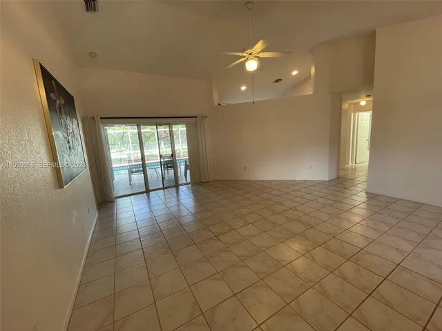 an empty room with stairs and wooden floor