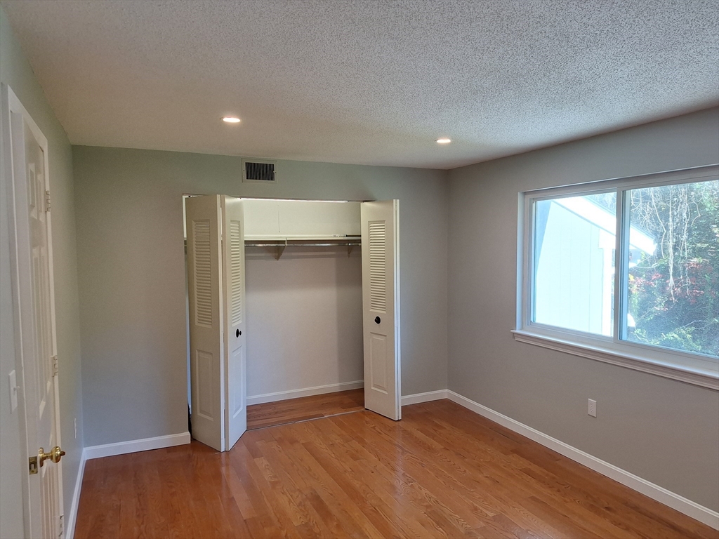 4 Beal's Cove Road, Unit F Hingham, MA 02043 - Photo 11 of 22 an empty room with wooden floor and windows