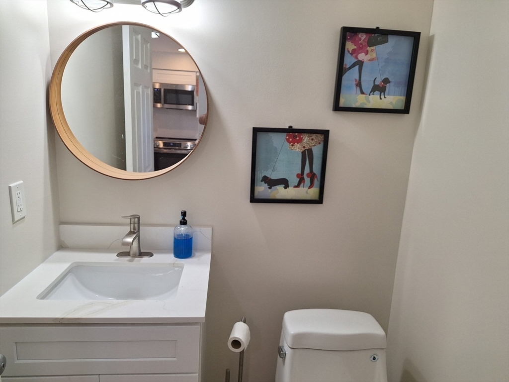 4 Beal's Cove Road, Unit F Hingham, MA 02043 - Photo 15 of 22 a bathroom with a toilet a sink and mirror