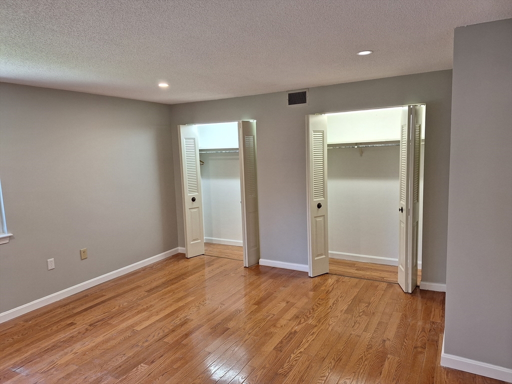 4 Beal's Cove Road, Unit F Hingham, MA 02043 - Photo 2 of 22 an empty room with wooden floor and closet
