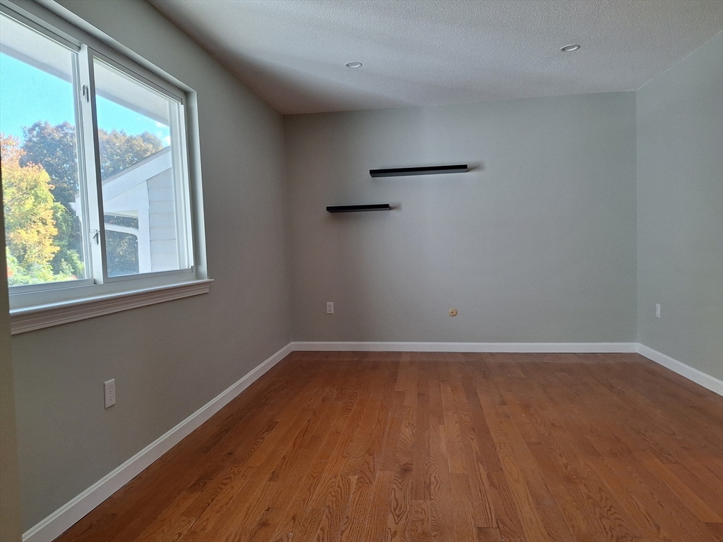 4 Beal's Cove Road, Unit F Hingham, MA 02043 - Photo 8 of 22 an empty room with wooden floor and windows