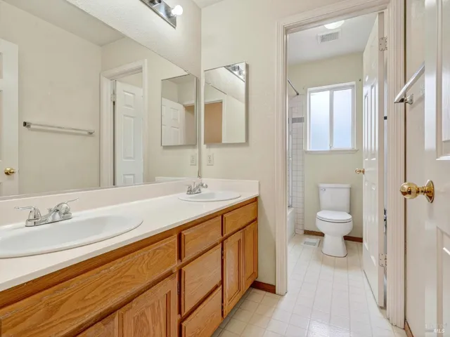 a spacious bathroom with a toilet a sink and mirror