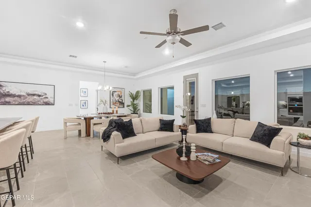 a living room with furniture a ceiling fan and a rug