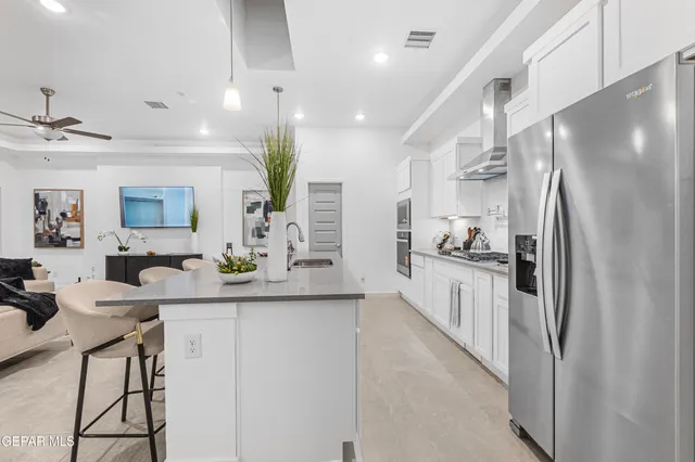 a kitchen with stainless steel appliances a refrigerator sink and microwave