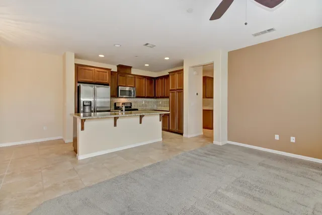 a view of kitchen with stainless steel appliances refrigerator oven and cabinets