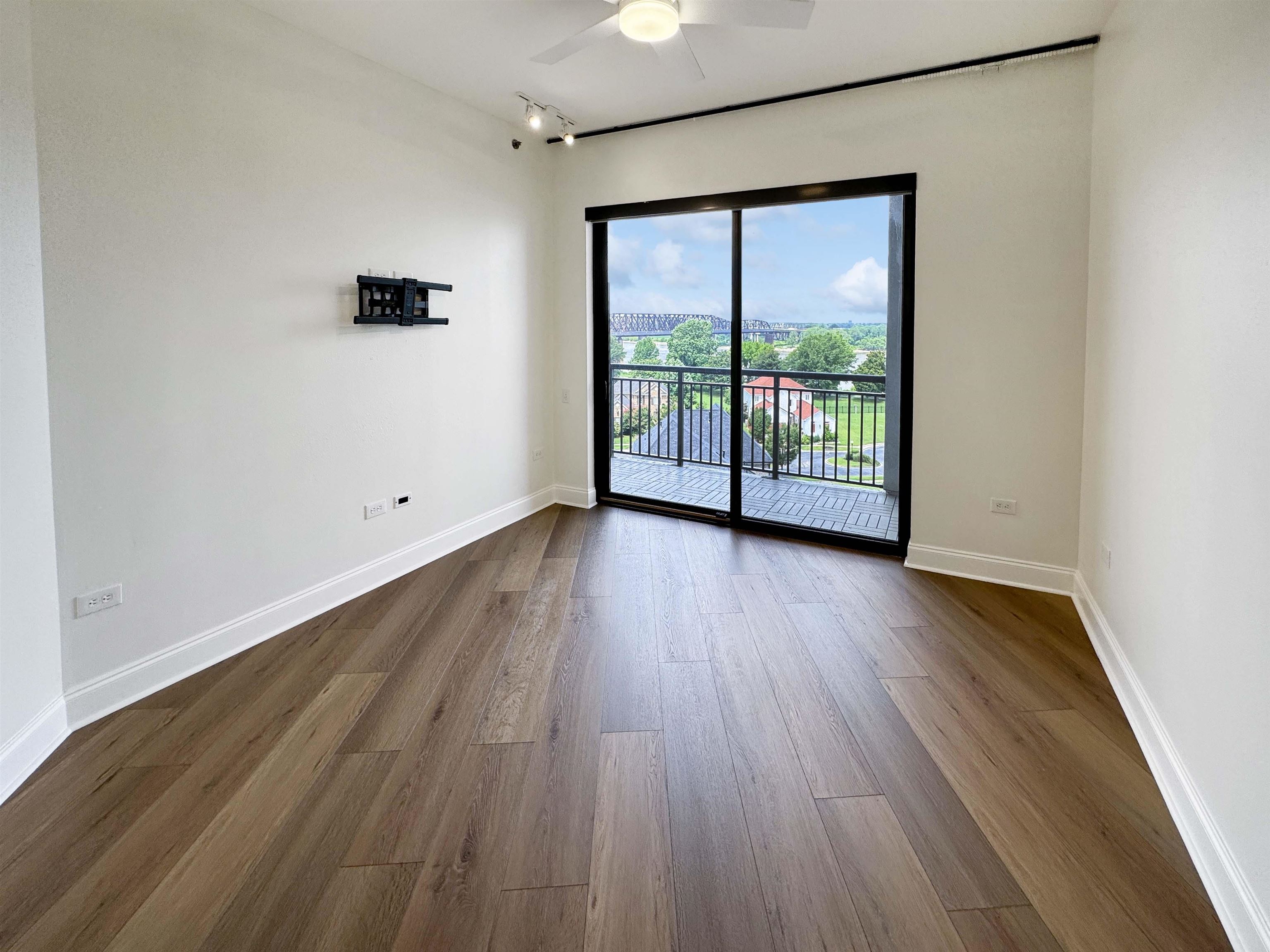 717 Riverside Drive, Unit 707 Memphis, TN 38103 - Photo 6 of 39 Empty room featuring ceiling fan, track lighting, and dark wood-type flooring