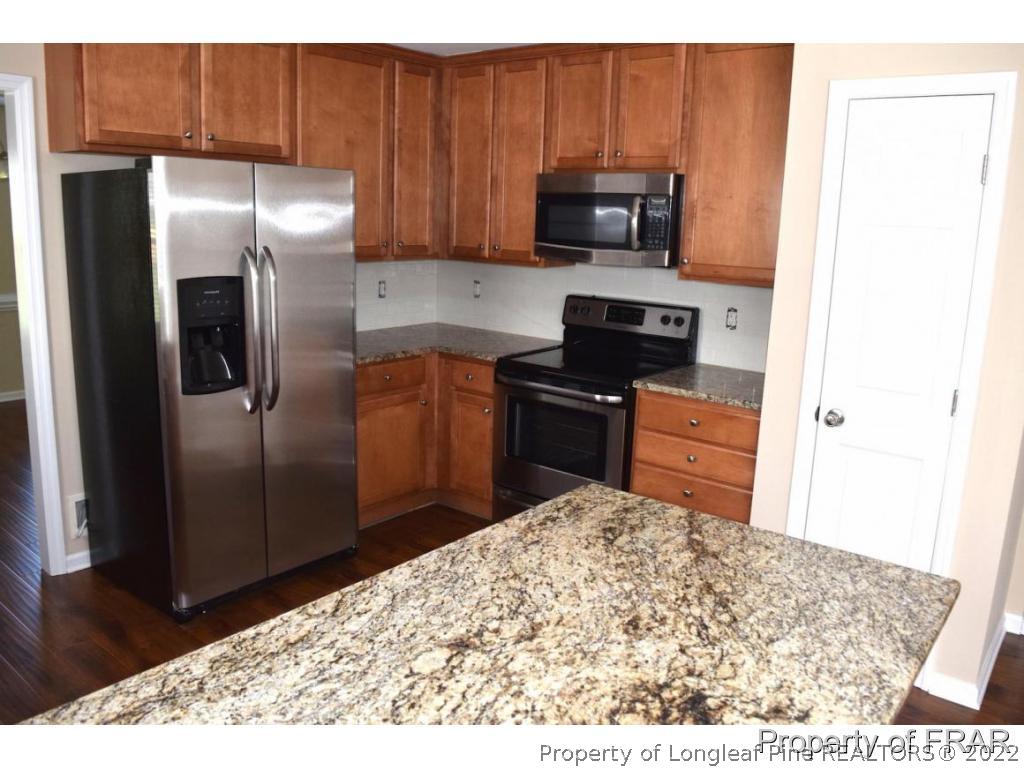 192 Lennox Loop Raeford, NC 28376 - Photo 16 of 33 a kitchen with granite countertop a refrigerator and a sink