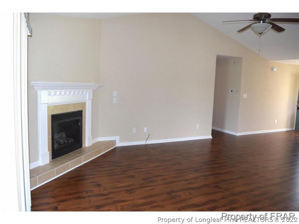192 Lennox Loop Raeford, NC 28376 - Photo 8 of 33 a view of an empty room with wooden floor and a fireplace