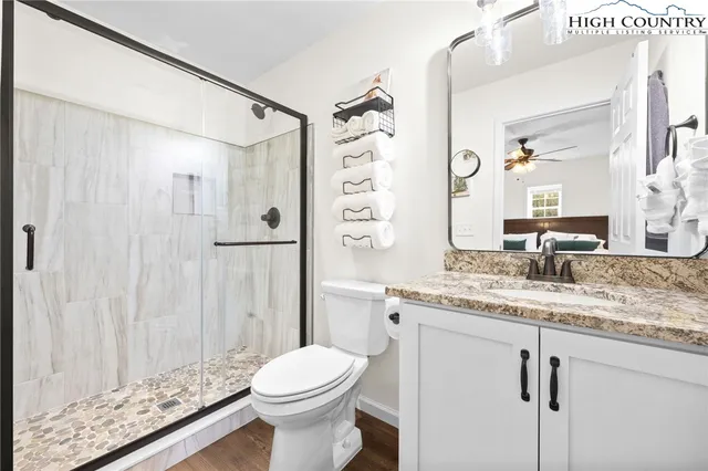 a bathroom with a granite countertop sink toilet and shower