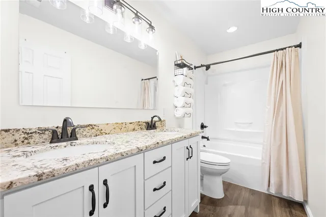 a bathroom with a granite countertop sink toilet and shower