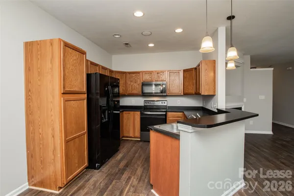 a kitchen with stainless steel appliances granite countertop a refrigerator a sink and a stove