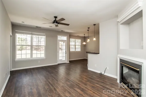 a view of an empty room with a fireplace and a window
