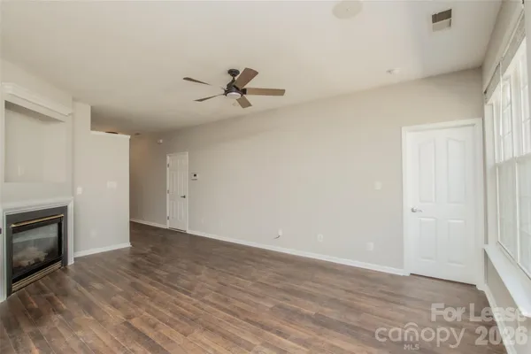 a view of empty room with wooden floor and fireplace