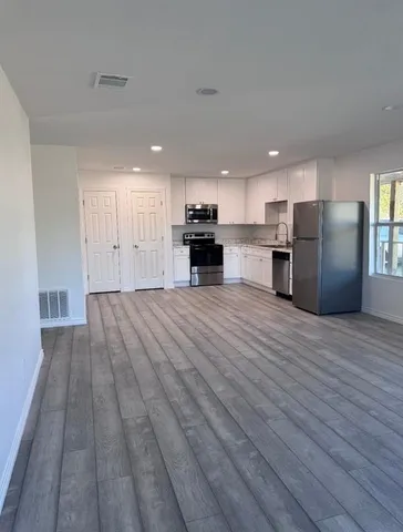 a view of a kitchen with a sink and a refrigerator