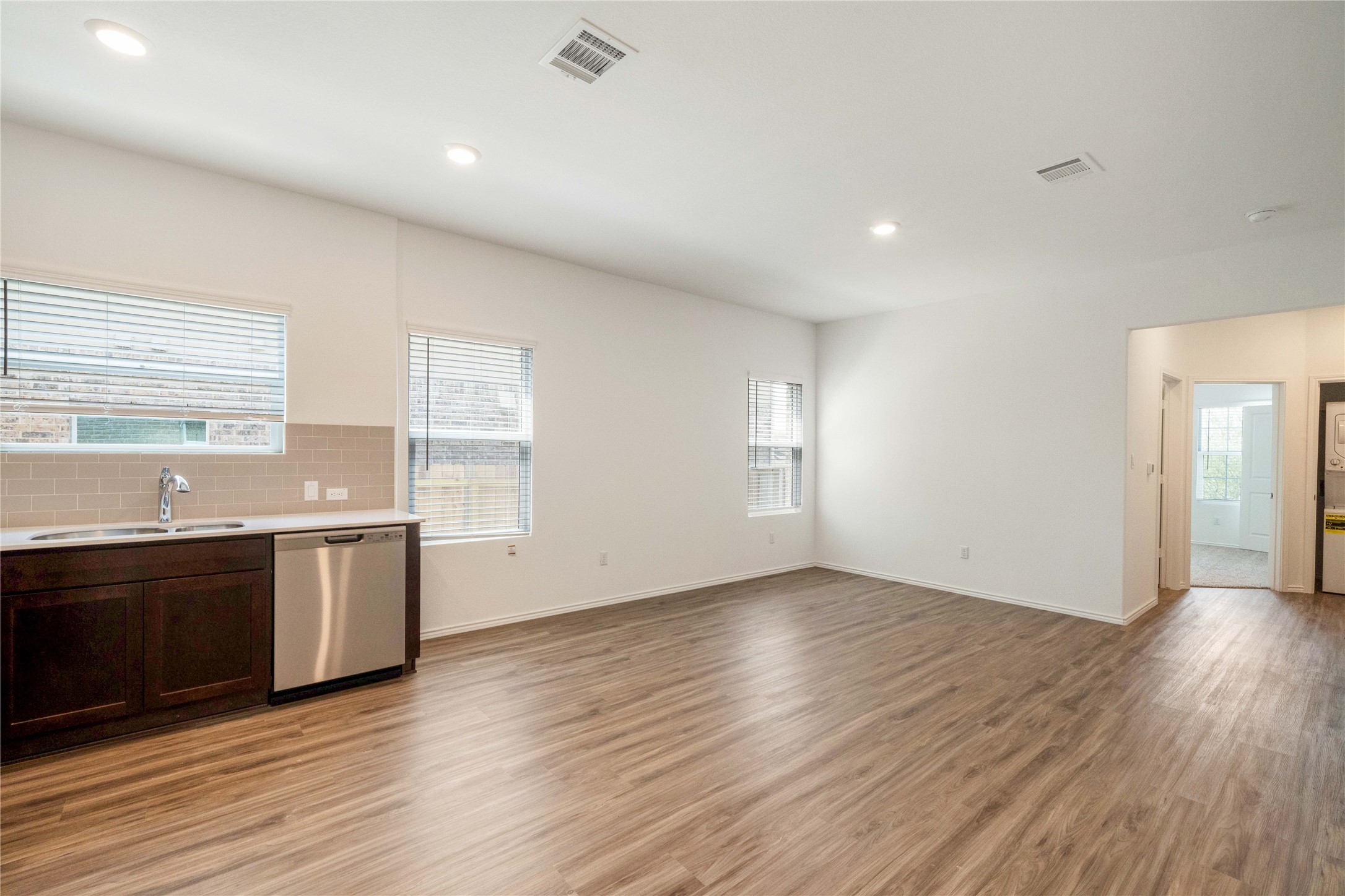 932 Mallow Road Leander, TX 78641 - Photo 24 of 40 Open-concept living area with wood-finish flooring, recessed lighting, and white walls