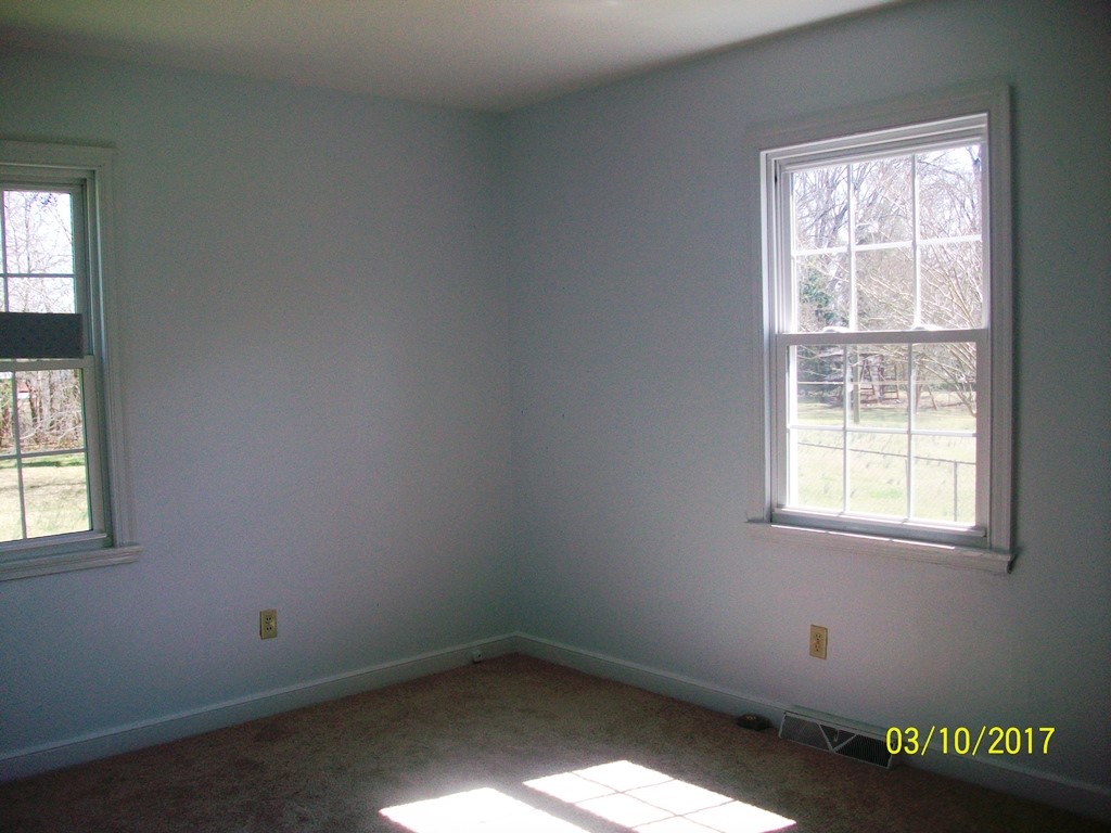 2040 Corinth Drive Seneca, SC 29672 - Photo 3 of 10 This cozy bedroom features bright windows overlooking the surrounding natural landscape.