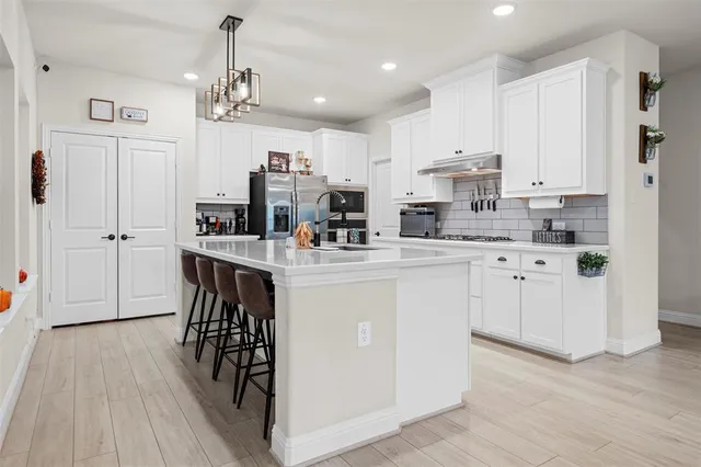 a kitchen with cabinets and wooden floor
