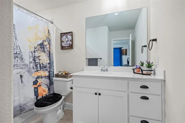 a bedroom with a bed and a flat tv screen on dresser