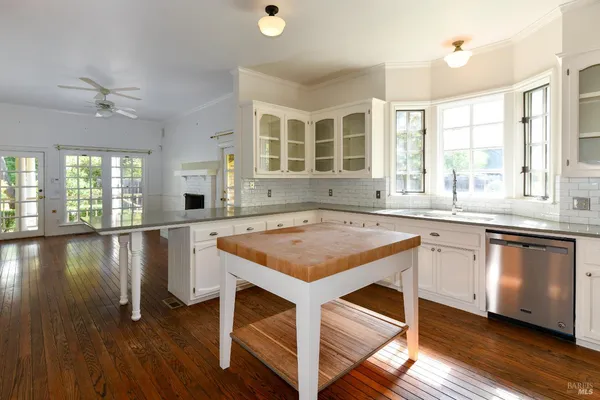 a kitchen with granite countertop a stove a sink a window and wooden floor
