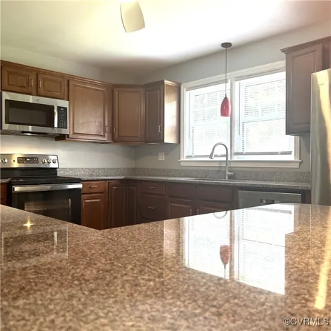 a kitchen with stainless steel appliances granite countertop a sink a stove and a microwave