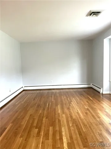 a view of an empty room and wooden floor