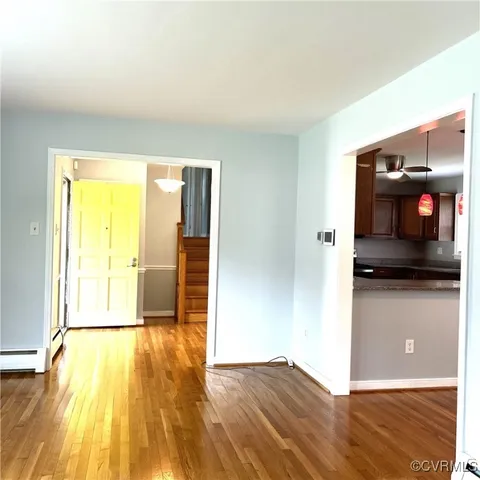 a view of a living room with wooden floor and a bed
